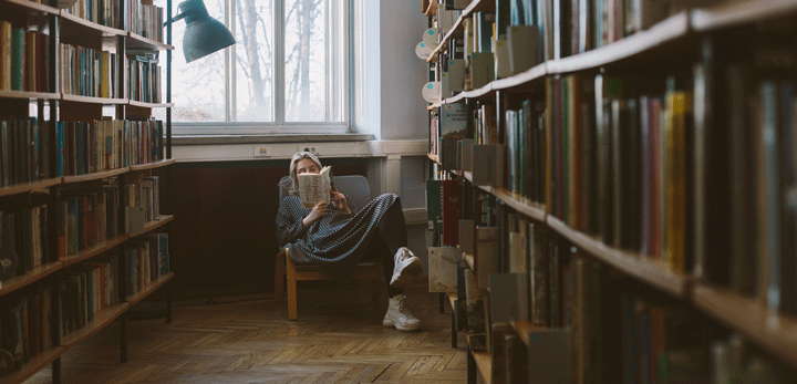 Chica leyendo en la biblioteca